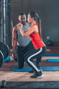 trainer at the gym with female client